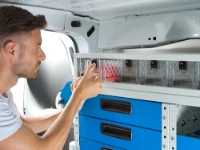Operatore che utilizza le cassettiere a cassetti trasparenti nel furgone